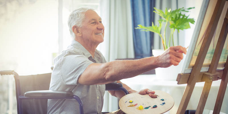 A senior man enjoying painting artwork.
