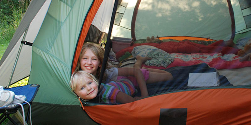 Kids camping in a tent.