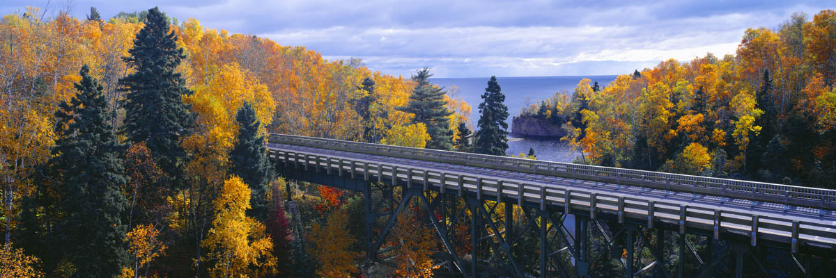 A bridge overlooking a lake and trees during autumn.